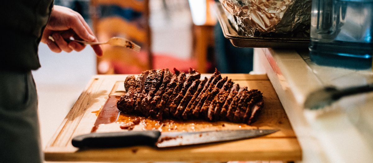 Delicious sliced brisket on a wooden board, perfect for a cozy indoor meal.