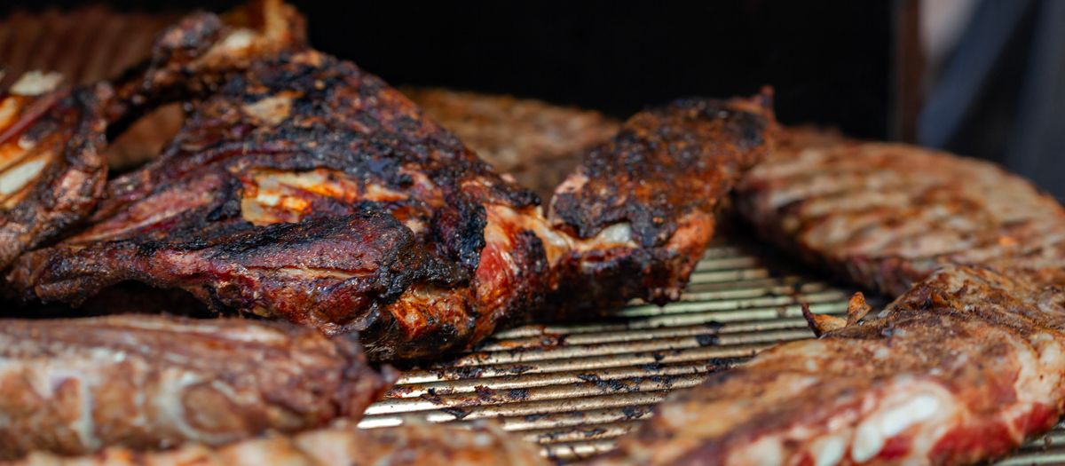 Several pellet grills lined up at a backyard cookout.