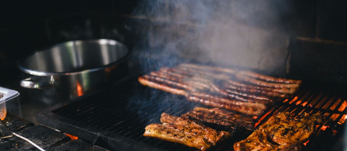 A pellet grill controller and lid thermometer on a backyard smoker.