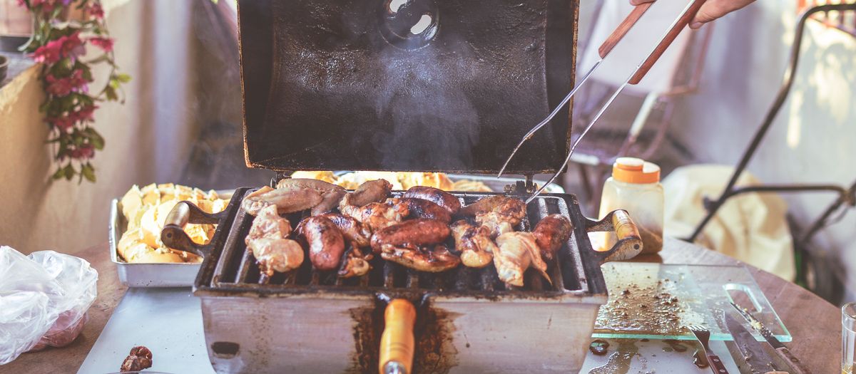 Grilled meats and vegetables cooking on an outdoor barbecue grill. Perfect for summer gatherings.